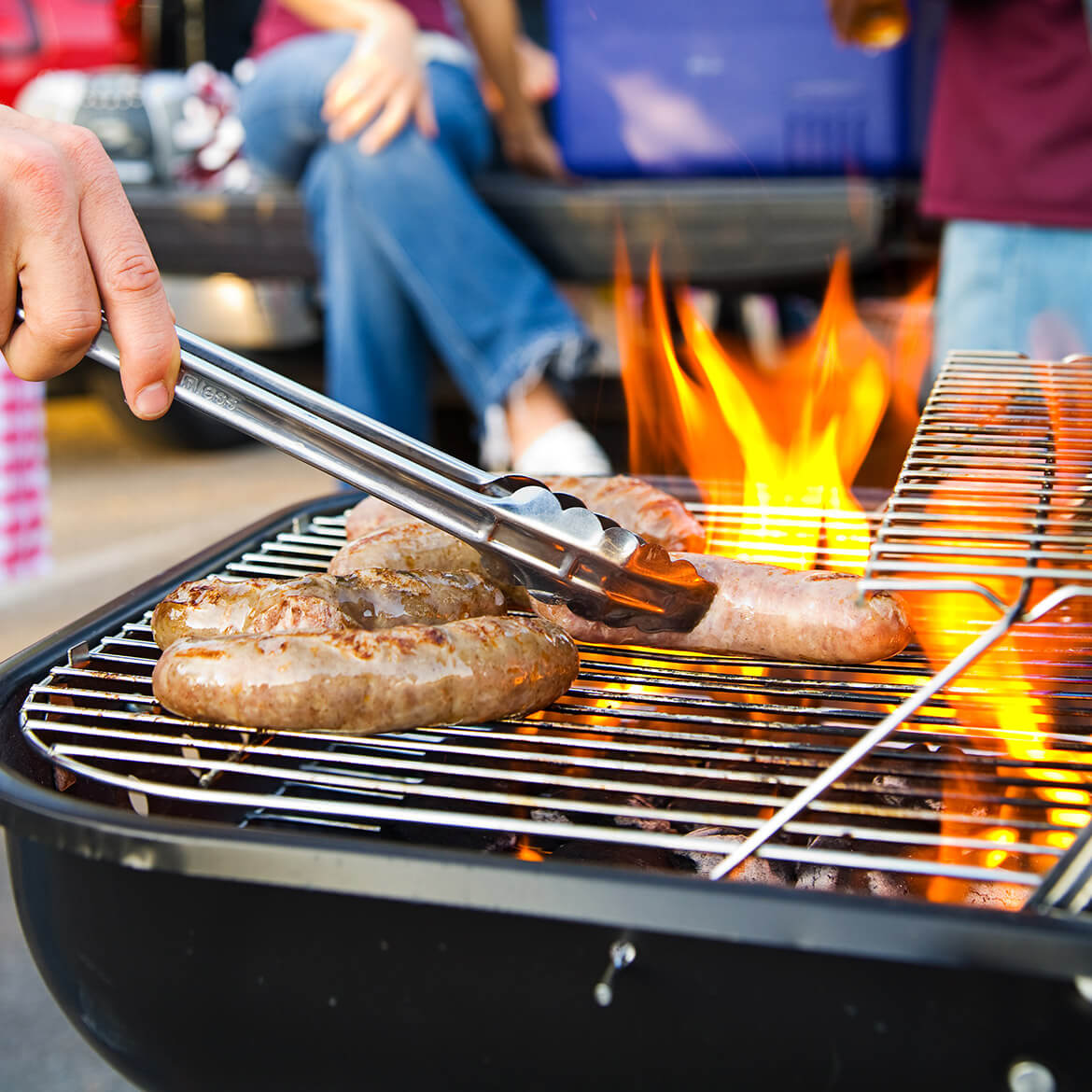 Flamed grill and someone flipping sausages.